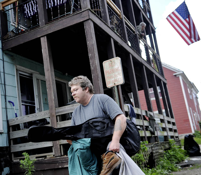 Kevin Vigue removes belongings from the apartment he's shared with his brother and uncle at 6 York St. in Augusta today, after city code enforcement, fire department and health officials ordered tenants to vacate the building because of unsafe conditions The Vigues and their uncle, Roger Nadeau, say they have lived on the second floor for about 20 years.