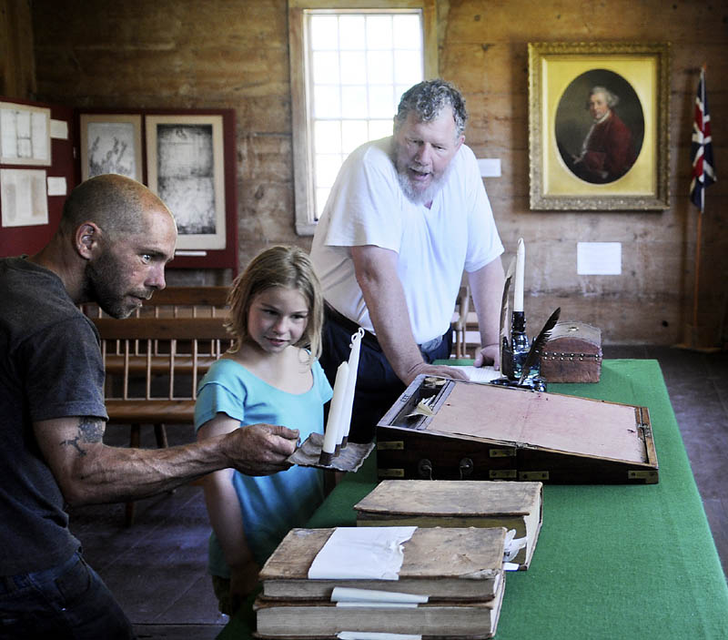 Jay Robbins, right, of the Lincoln County Historical Association, gives Eric Barter, left, and his daughter, Eliza, a tour of the courtroom at the Pownalborough Court House in Dresden. The grounds of the 18th Century building that served as an inn, court and home hosted Dresden Summer Fest on Sunday.