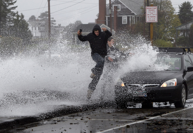 Caleb Lavoie, 17, of Dayton, Maine, front, and Curtis Huard, 16, of Arundel, Maine, leap out of the way as a large wave crashes over a seawall on the Atlantic Ocean during the early stages of Superstorm Sandy, in Kennebunk, Maine.