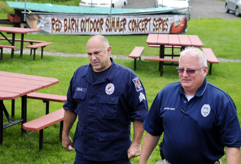 Lewiston Police officers Cpl. Jeffrey Baril, right, and Sgt. Michael Whalen walk past an outdoor stage, at top, Tuesday at The Red Barn restaurant in Augusta. Baril and Whalen stopped for lunch after attending a meeting in Augusta.