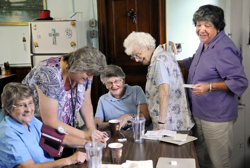 Members of the Chelsea Senior Citizens laugh Monday while comparing their blood pressure during a weekly meeting of the group on the Windsor Road. Marilyn Gagnon, left, Esther Shaw, center, Noreen Robinson and Winona Massey, right, along with other members of the group, received free checks of their blood pressure from nurse Kelley Cowing, second from left. The group meets every Monday from 11 a.m. to 2 p.m. for activities, including games, poetry readings and socializing.