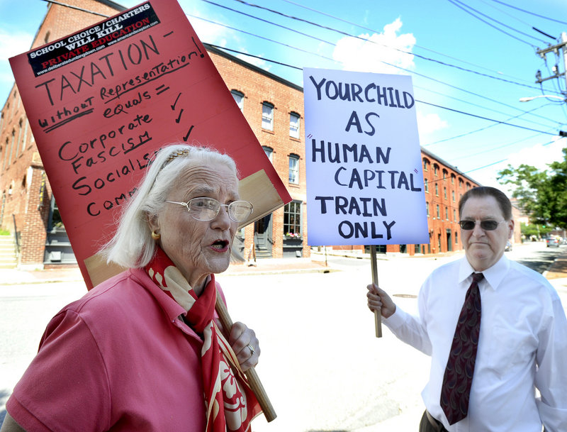 Charlotte Iserbyt of Dresden and Steve Schran of New Gloucester protested outside the Maine Heritage Policy Center luncheon at Baxter Academy in Portland on Wedmnesday, July 31, 2013.