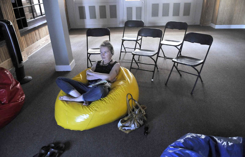 Karen Young watches a MiffOnEdge presentation of Nam Jun Paik's "Global Groove" from a bean bag chair at the old post office in downtown Waterville on Saturday.