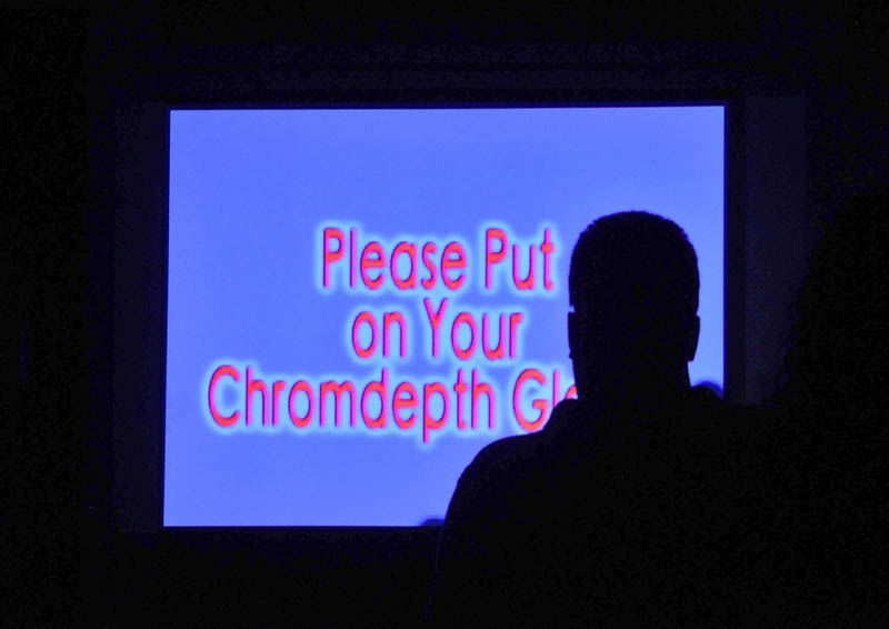 A Maine International Film Festival-goer watches Kerry Laitala's "Chromadepth Works" at the old post office in downtown Waterville on Saturday.