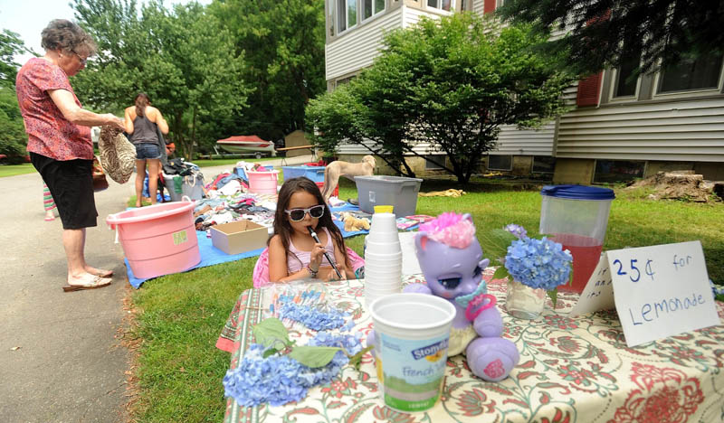 Skylah Rayne Breault-Talon, 7, serenades shoppers with her recorder at her lemonade stand, set up at her mother's yard sale on Silver Street in Waterville on Sunday.
