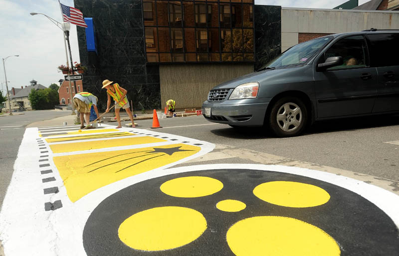 Pat Burdick, right, and her covivant, Kevin James, left, paint a new Maine International FIlm Festival themed crosswalk on Main Street in downtown Waterville on Sunday. The crosswalk was styled to go along with the annual festival, scheduled to kick off July 12.