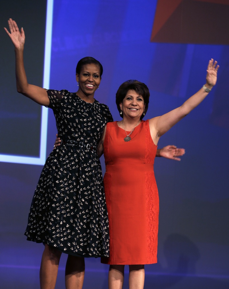 First lady Michelle Obama and National Council of La Raza President Janet Murguia wave as she arrives onstage to speak about childhood obesity, Tuesday, July 23, 2013, at the NCLR annual meeting New Orleans. The conference and a related "Family Expo" were expected to draw an estimated 25,000 participants. (AP Photo/Gerald Herbert)