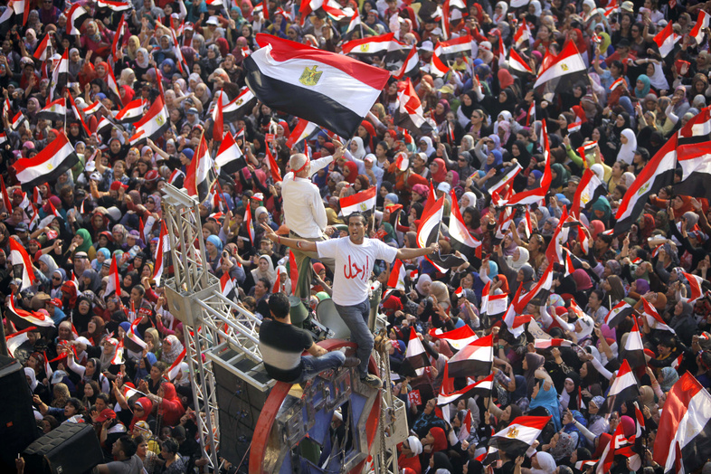 Opponents of Egypt's Islamist President Mohammed Morsi shout slogans and wave a national flags in Tahrir Square in Cairo, Egypt, on Wednesday. The Arabic says, "leave."
