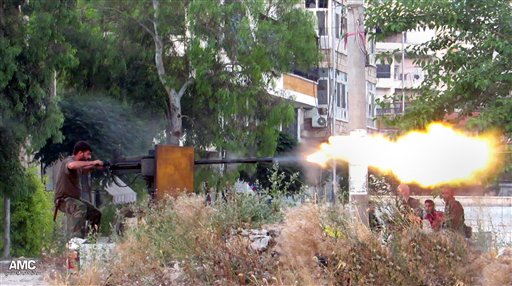 This citizen journalism image provided by Aleppo Media Center AMC, which has been authenticated based on its contents and other AP reporting, shows a Syrian rebel firing a heavy machine gun toward soldiers loyal to Syrian president Bashar Assad, in Aleppo, Syria, on June 20.