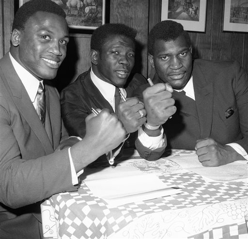 FILE - In this Jan. 3, 1968 file photo, boxer Emile Griffith is flanked by boxers Joe Frazier, left, and Buster Mathis in New York. The International Boxing Hall of Fame says former world champion boxer Emile Griffith has died. He was 75. The hall said Tuesday, July 23, 2013, he died at an extended care facility in Hempstead, N.Y.(AP Photo/File)