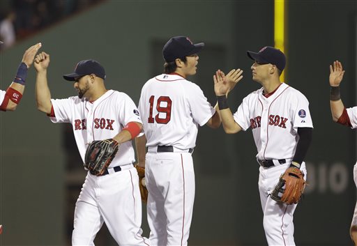 Boston Red Sox closer Koji Uehara (19) and teammates Shane Victorino, left, and Jose Iglesias, right, celebrate after they defeated the San Diego Padres 4-1 in an interleague baseball game at Fenway Park in Boston, Tuesday, July 2, 2013. (AP Photo/Elise Amendola)