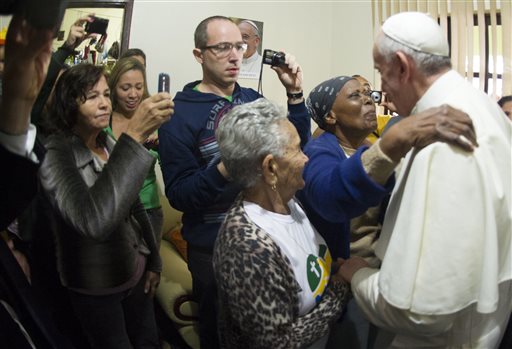 In this Thursday photo provided by the Vatican newspaper L'Osservatore Romano, Pope Francis meets with residents of the Varginha community in Rio de Janeiro. As a cardinal, Francis showed a special concern for the elderly that continues in his pontificate. But he's likely also aware of demographic trends in the church and society at large. The percentage of elderly is growing steadily around the globe, and caring for them is expected to become a major challenge.