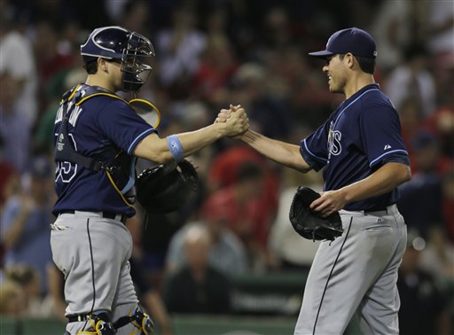 Tampa Bay Rays starting pitcher Matt Moore, right, is congratulated by catcher Jose Lobaton after throwing a complete game and beating the Boston Red Sox in a baseball game at Fenway Park, Monday, July 22, 2013, in Boston. The Rays beat the Red Sox 3-0. (AP Photo/Charles Krupa)