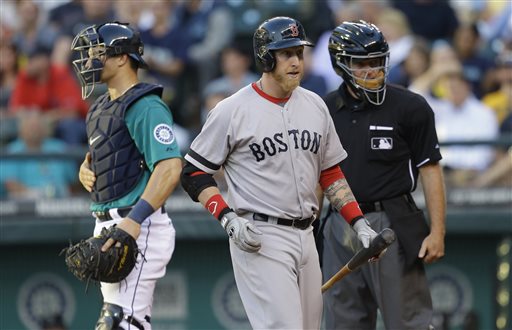 Boston Red Sox' Mike Carp, center, walks to the dugout after being called out on strikes by home plate umpire Ed Hickox, right, in the fourth inning of a baseball game, Monday, July 8, 2013, in Seattle. Mariners catcher Mike Zunino is at left. (AP Photo/Ted S. Warren)