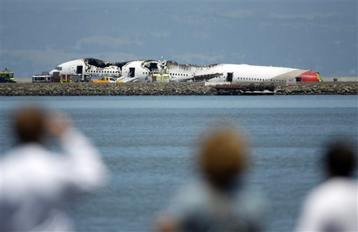People look at the wreckage of Asiana Flight 214 where it crashed at San Francisco International Airport in San Francisco on Saturday.