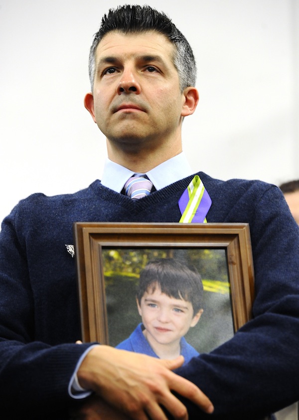 In this Jan. 14, 2013 file photo, Ian Hockley, father of Sandy Hook School shooting victim Dylan, holds a photo of his son at a news conference at Edmond Town Hall in Newtown, Conn. Some Newtown families have said they were given a voice late in the process of dispersing the millions of dollars in donated funds, and that the process has been bureaucratic, difficult, unpleasant, and has added to their pain. “What’s the objective here?” Hockley said. “The objective is to heal Newtown and to take care of its most affected people.” (AP Photo/Jessica Hill, File)