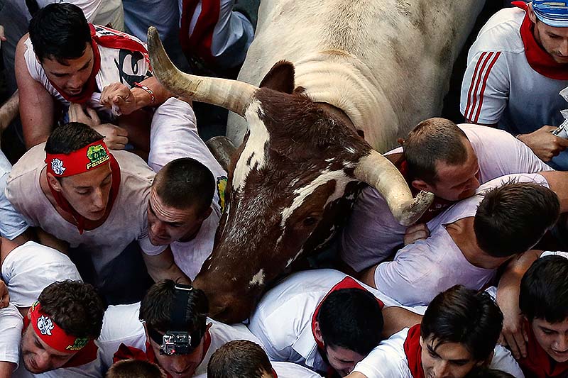 Revelers are jammed into the narrow streets during Sunday's running of th bulls at the San Fermin festival in Pamplona, Spain. Revelers from around the world arrive to Pamplona every year to take part on some of the eight days of the running of the bulls glorified by Ernest Hemingway's 1926 novel "The Sun Also Rises."