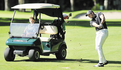 WATCHFUL EYE: Justin Speirs Jr. watches from the cart as his uncle Jesse Speirs drives off the fairway on the back nine during the Charlie’s Maine Open Championship on Tuesday at the Augusta Country Club in Manchester. Speirs tied for second with a six under par two day total of 134.