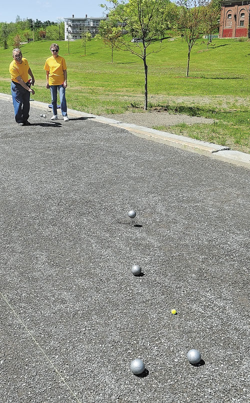 THIS IS HOW: Ray, left, and Lucette Fecteau demonstrate how to play pétanque at Mill Park in Augusta. The couple will host a tournament Sunday at the park.