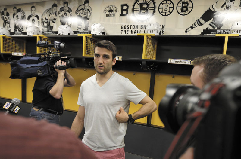RIGHT HERE: Boston Bruins center Patrice Bergeron gestures towards a broken rib on his left side as he talks with reporters in the team locker room Tuesday in Boston. Bergeron played through a multiple injuries including a broken rib, separated shoulder and hole in his lung during the Stanley Cup finals.