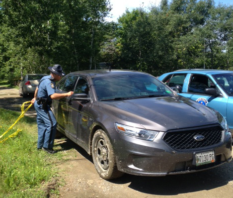 A Maine state trooper speaks with a detective leaving the scene where a dead male was discovered at 24 Main Street in Detroit Thursday morning. The Major Crimes Unit is parked at the mobile home.