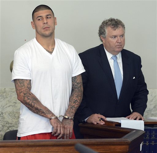 Former New England Patriots tight end Aaron Hernandez, left, stands with his attorney Michael Fee, right, during arraignment in Attleboro District Court Wednesday, June 26, in Attleboro, Mass. Hernandez was charged with murdering Odin Lloyd, a 27-year-old semi-pro football player for the Boston Bandits, whose body was found June 17 in an industrial park in North Attleborough, Mass. (AP Photo/The Sun Chronicle, Mike George, Pool)