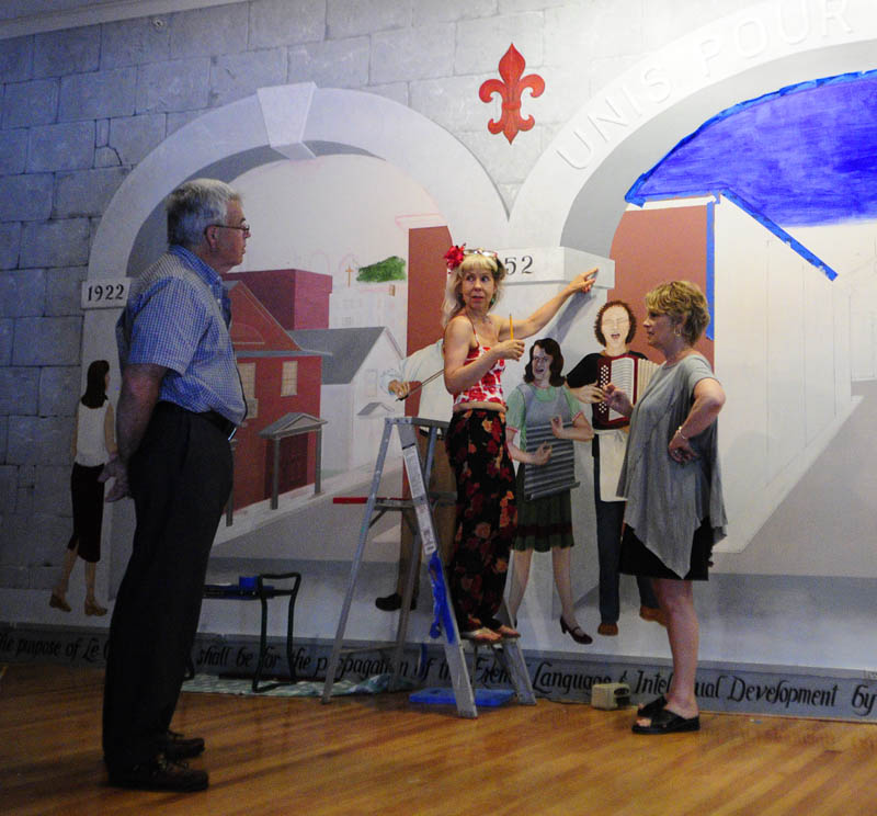 Don White, left, Jane Burke and Corliss Chastain on July 19 talk about what words to put on the side of a column being painted as part of a mural at Le Club Calumet in Augusta.