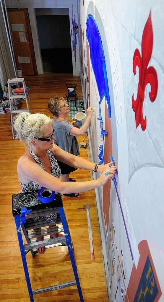 Linda Lancaster, top, paints while Corliss Chastain works on another part of a mural on July 19 at Le Club Calumet in Augusta.