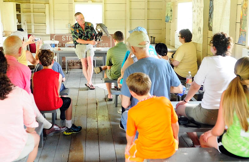 Falconer Larry Barnes talks about a Peale's peregrine falcon that he hunts ducks with in the winter, during a talk on Saturday in the boat house at the Steve Powell Wildlife Management Area, on Swan Island between Richmond and Dresden.