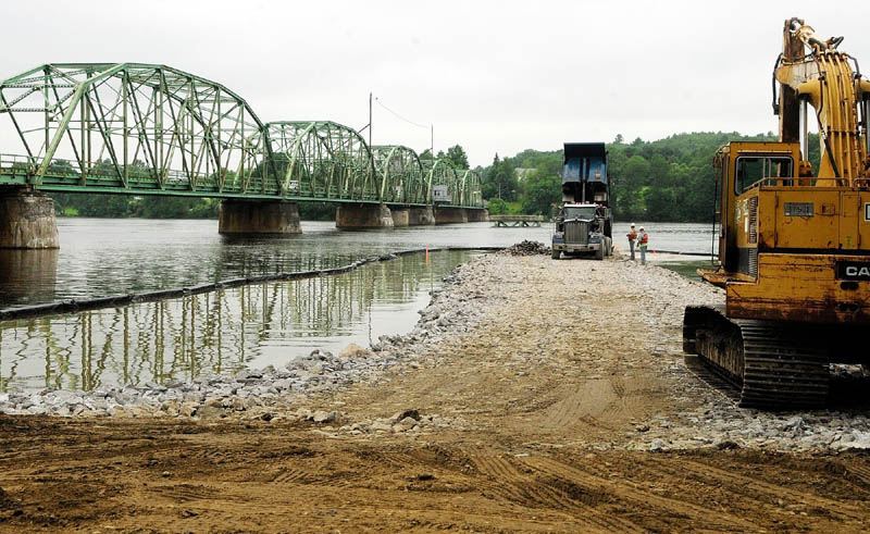 Construction crews work on a construction causeway on the Kennebec River Wednesday.