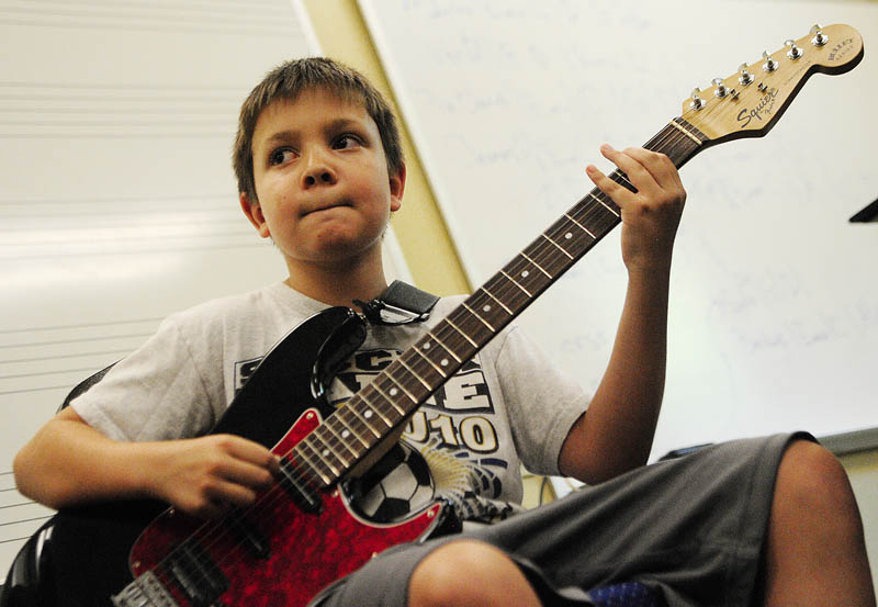 William McPherson, 10 of Oakland, plays his guitar during Rock Camp on Wednesday at the University of Maine at Augusta. There were two bands rehearsing at the camp sponsored by Maine Academy of Modern Music.
