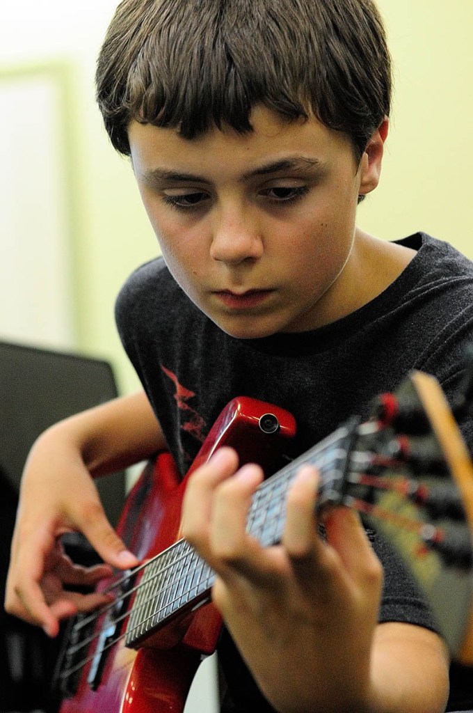 Connor McLean, 12, of Whitefield, plays bass during Rock Camp on Wednesday.