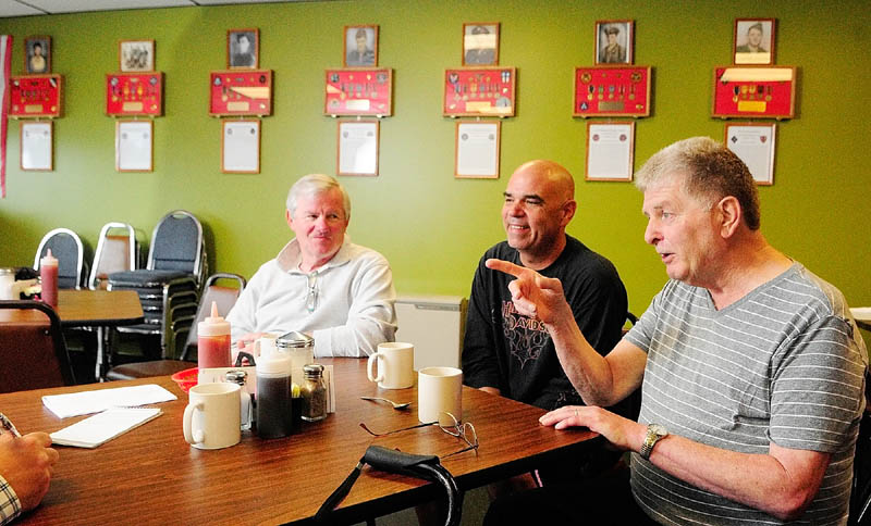 David Harville, left, Thomas "TJ" Quinn, center, and Larry Day talk about the memorial wall display during an interview on Tuesday at Quinn's TJ's Place, on Route 202 in Monmouth.