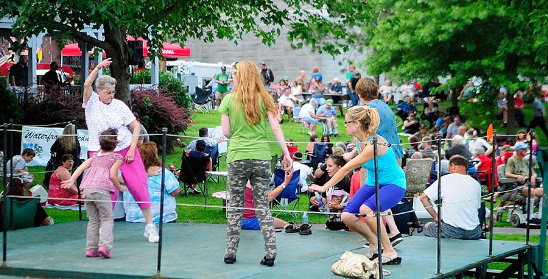 People dance on a stage to the music of the band Borderline Express, which is playing inside the gazebo, on Wednesday during a Waterfront Wednesday concert in Augusta's Waterfront Park. The annual concert series is sponsored by the Augusta Recreation Department., local radio stations B-98.5 and 92 Moose, and Walgreens.