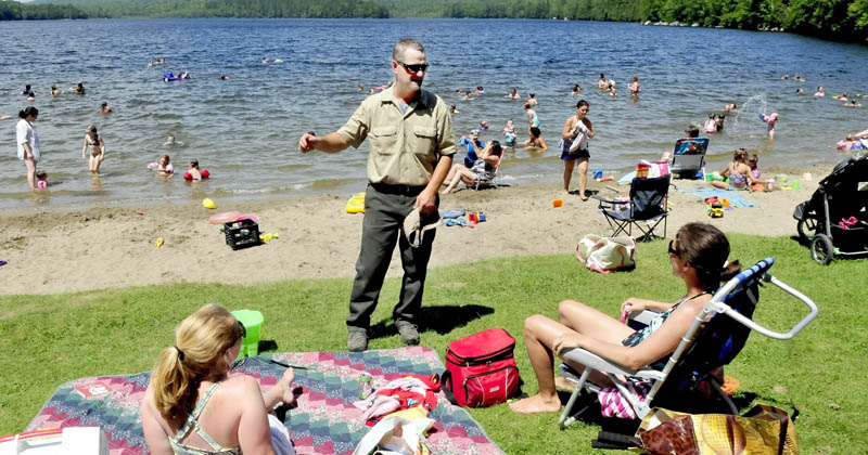 Derek Ellis, the new Lake George Regional Park ranger, speaks with people at one of the crowded beaches on the Canaan side of the lake on July 16.