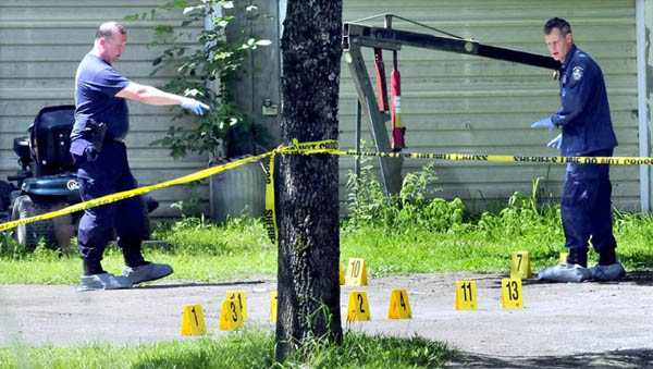 Maine State Police detectives mark evidence in the driveway at a mobile home at 24 Main Street in Detroit after a deceased male was found early Thursday.