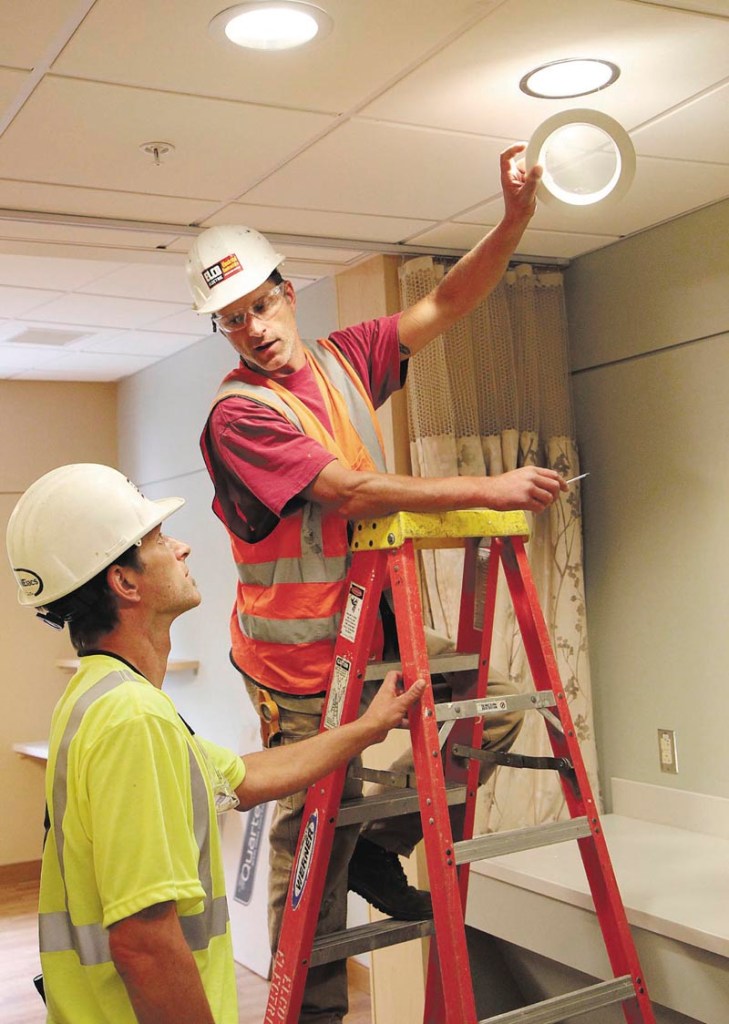 Steve Flanders, on ladder, works with his twin brother, Seth, while installing light fixtures inside Sebasticook Valley Hospital's new inpatient wing in Pittsfield on Wednesday. The brothers work for Elco Electric out of Bangor.