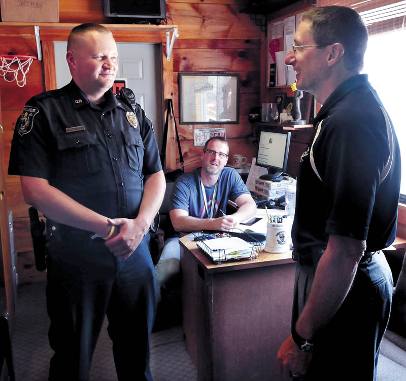 Former Waterville police officer Todd Burbank, left, speaks with Oakland Police Chief Mike Tracy,right, as Capt. Rick Stubbert listens on June 24. Burbank is the new school resource officer.