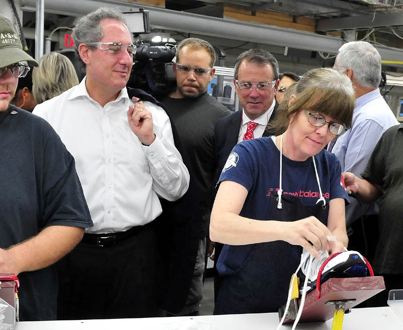 U.S. Trade Representative Michael Froman observes New Balance employee Vicky Dionne lace a new sneaker at the Norridgewock plant today.