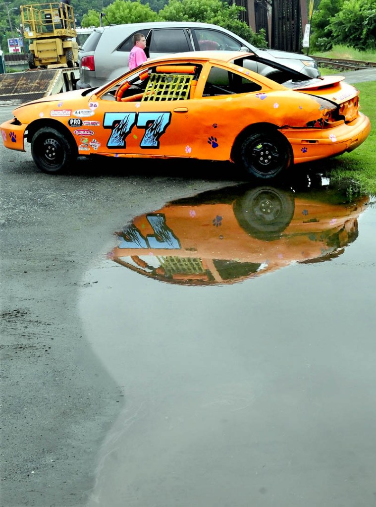 A race car is parked in a large puddle near Fort Halifax Park in Winslow on a wet Tuesday. The car is part of the Winslow Family 4th of July's "Total Truck Experience," where kids get a chance to see, up-close, municipal and commercial trucks.