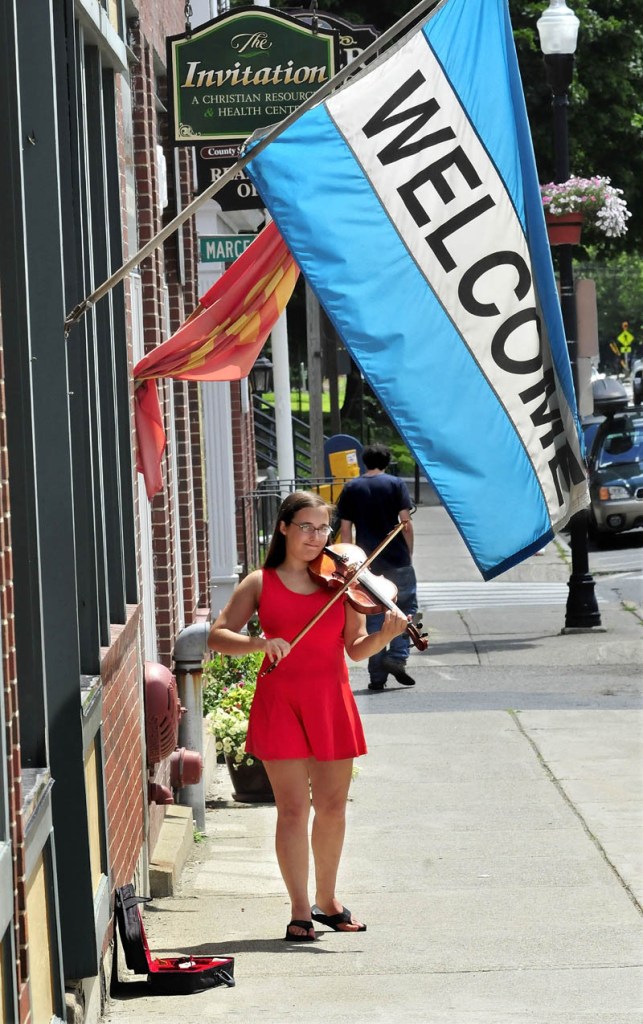 Ashley Taylor, of Chesterville, plays her violin on Main Street in Farmington today. Appreciative walkers often drop some money in her open instrument case. "I really enjoy playing in public," Taylor said.