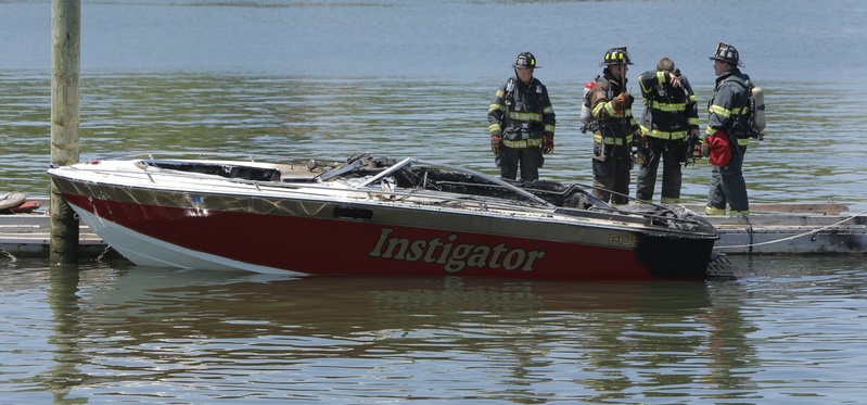 Portland firefighters examine a boat that exploded and caught fire at the boat launch at the Eastern Prom in Portland on Friday.