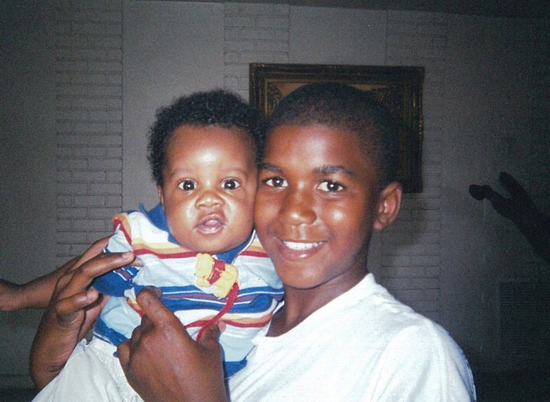 In a photo provided by the Martin family, Trayvon Martin holds an unidentified baby. Jurors could begin deliberating as early as Friday about whether George Zimmerman murdered Martin or acted in self-defense.