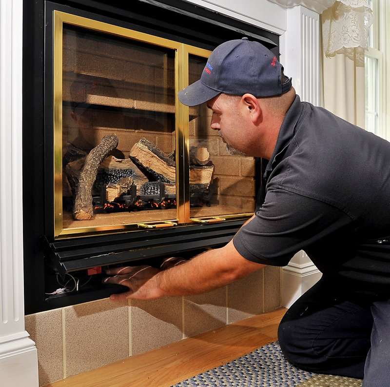 Mike Aboud, a service technician for Dead River Company, tests the prooane system for leaks and poor performance of a fireplace insert at a home in Scarborough on Friday, June 28, 2013.