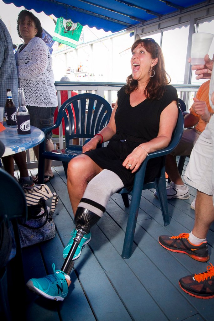 Boston Marathon bombing victim Karen Rand greets a friend Sunday at a fundraiser at The Brunswick.