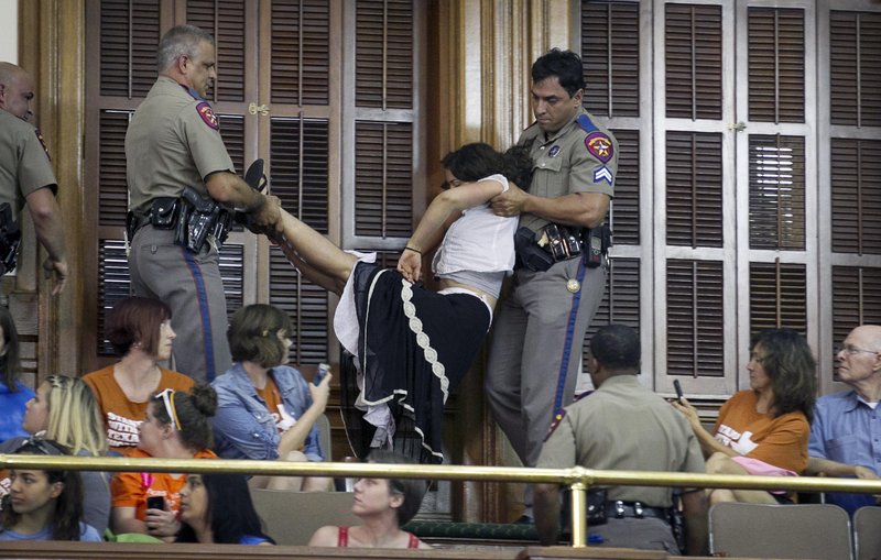 Police arrest a woman in the Senate Chamber at the Capitol in Austin, Texas, during the abortion debate Friday.
