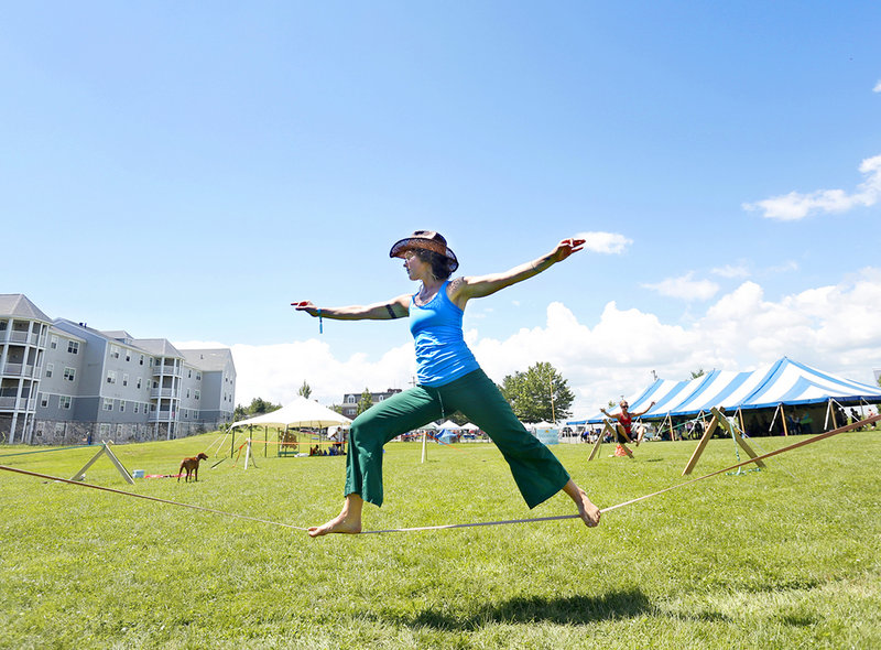 Instructor Meaghan Minogue performs a warrior II pose on a slack line during YogaFest at the East End Community School in Portland on Sunday.