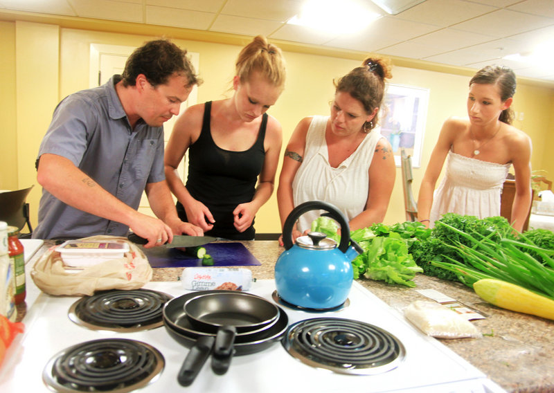 Tim Fuller, a health promotion specialist, demonstrates proper food chopping techniques at McAuley Residence.
