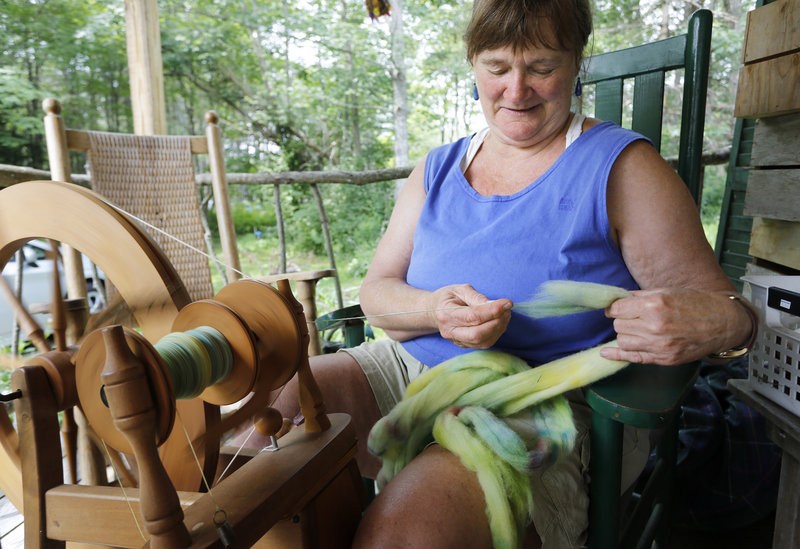 Dedee Montgomery, co-owner of Bessie’s Farm Goods in Freeport, spins wool Sunday during Maine Open Farm Day.