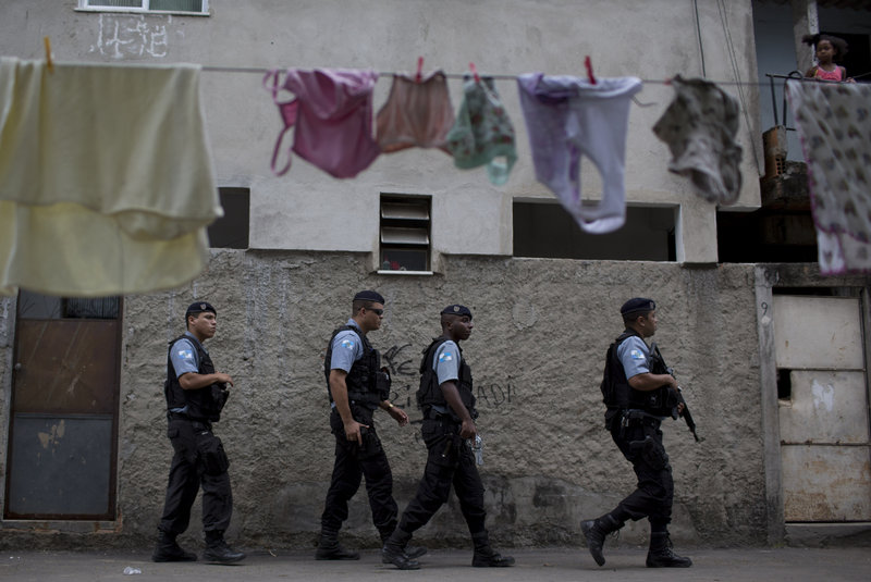 Policemen patrol Sunday in the Varginha area of the Manguinhos slum complex where Pope Francis will visit this week during his trip to Rio de Janeiro, Brazil.